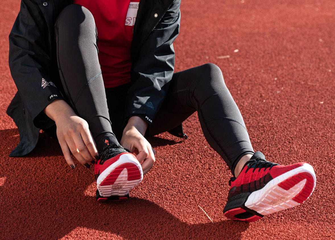 Девушка зашнуровывает кроссовки для бега | Peak Sport Ukraine